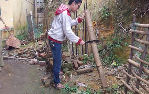 A boy cuts firewood. 